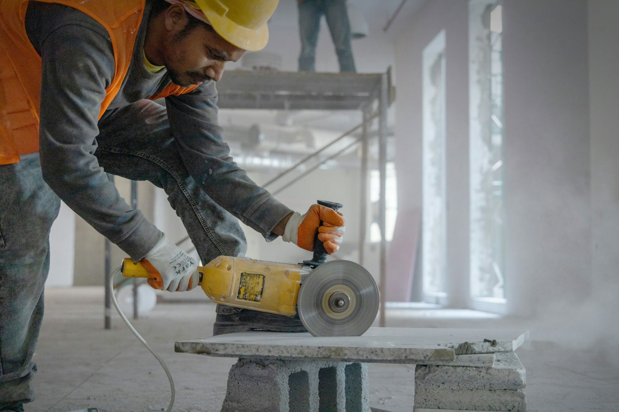 a-man-using-a-grinder-on-a-piece-of-concrete.jpg a man using a grinder on a piece of concrete